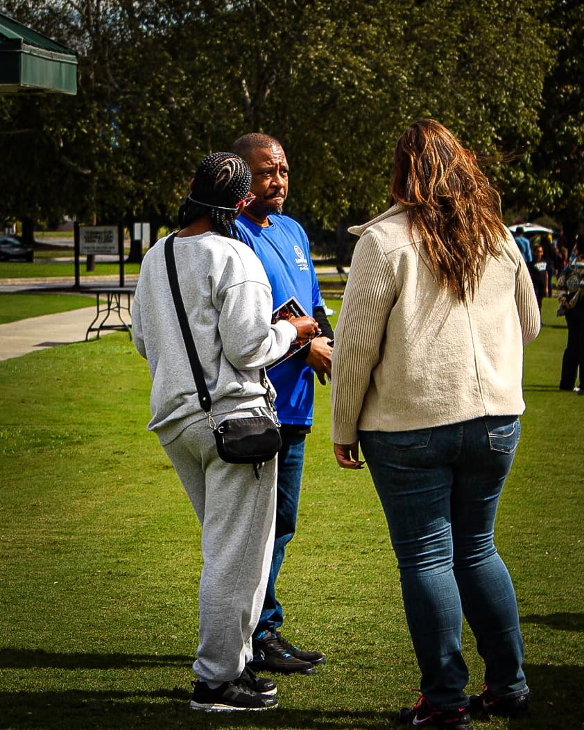 Greg Covert speaking with community members during the outdoor event